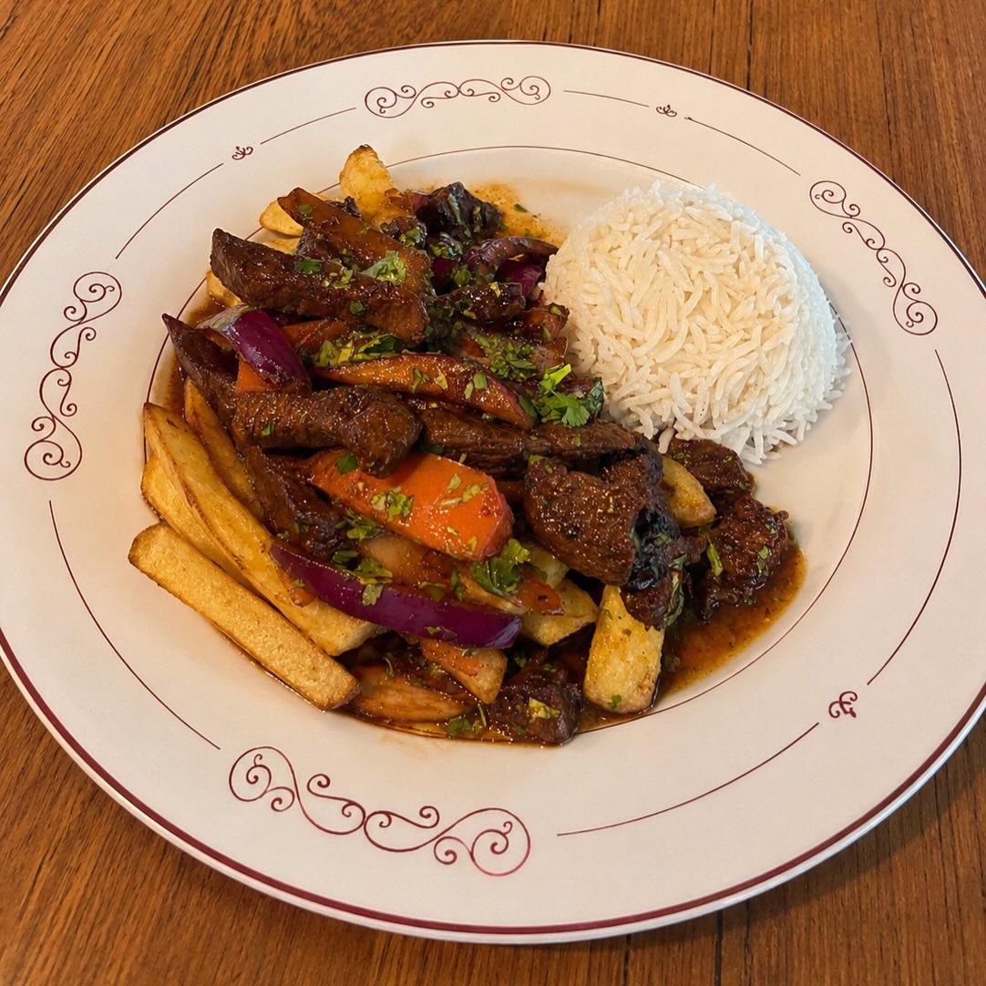 Peruvian lomo saltado served with rice and potatoes