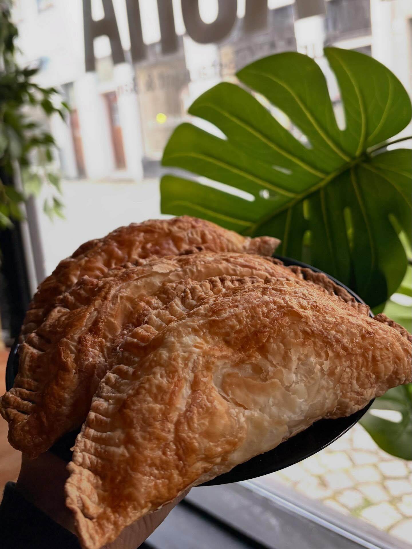 Single golden empanada with garnish